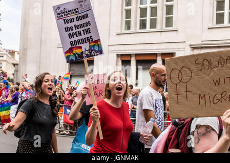 London, UK. 8. Juli 2017. Junge Frauen halten Protest unterschreiben gegen anti-Immigration Policiies während der Pride London 2017. Tausende von Menschen kommen die jährliche LGBT Parade durch die Hauptstadt. Bildnachweis: Nicola Ferrari/Alamy Live-Nachrichten Stockfoto