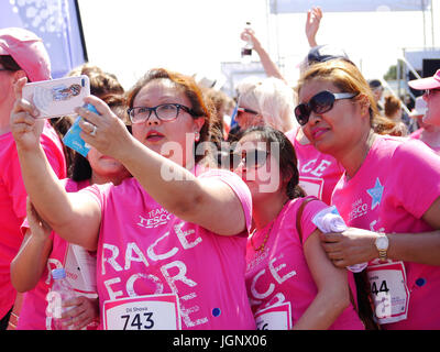 Portsmouth, UK, 9. Juli 2017. Eine Gruppe von Freunden nehmen ein Selbstporträt auf der Ziellinie der Portsmouth Rennen für Leben 2017. Das Rennen für das Leben ist ein 5k oder 10 k Rennen zugunsten der Krebsforschung Großbritannien. Es richtet sich an Frauen jeden Alters zusammen mit jungen. Bildnachweis: Simon Evans/Alamy Live News Stockfoto