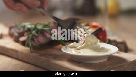 Schneiden Stück von Rib-Eye Steak und Dip-sauce Stockfoto