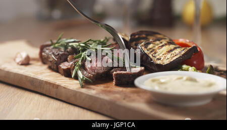 Schneiden Stück von Rib-Eye Steak und Dip-sauce Stockfoto