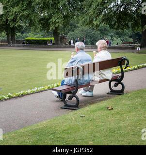 Genießen und zu teilen eine Eis paar in Bowling Green Yorkshire älter. Stockfoto