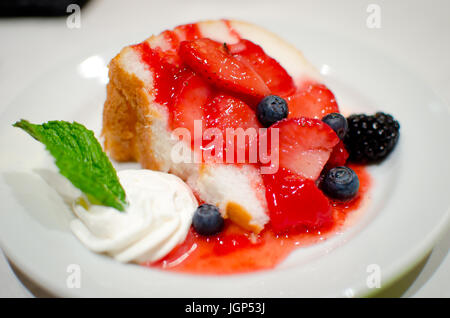 Angel Food Kuchen mit Erdbeeren und Schlagsahne. Stockfoto