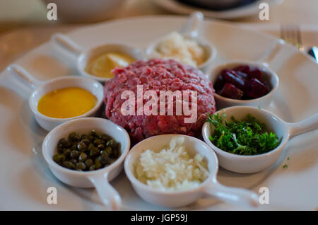Beef Tartare mit Auswahl der Zutaten hinzufügen Stockfoto