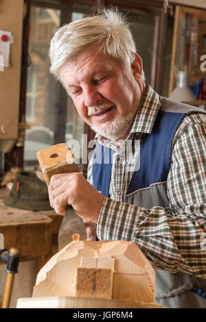 Holzmaske Carver mit Holzschnitzerei Tools auf einem Holzblock, Holzmaske, Bad Aussee, Steiermark, Österreich Stockfoto