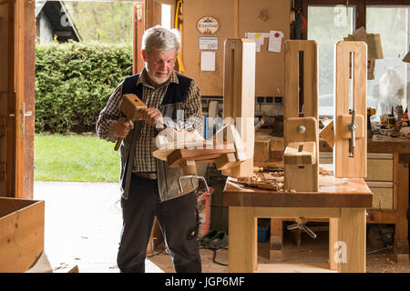 Holzmaske Carver mit Holzschnitzerei Werkzeugen an Werkbank in Werkstatt, Bad Aussee, Steiermark, Österreich Stockfoto