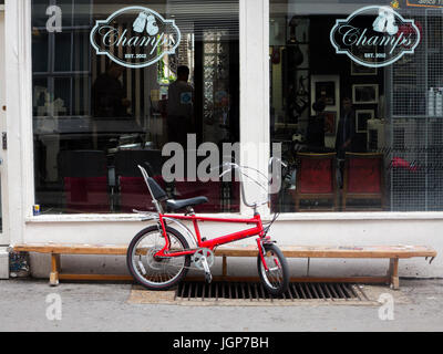 Ein 70er Jahre Chopper Fahrrad außerhalb einen Friseurladen in London Stockfoto