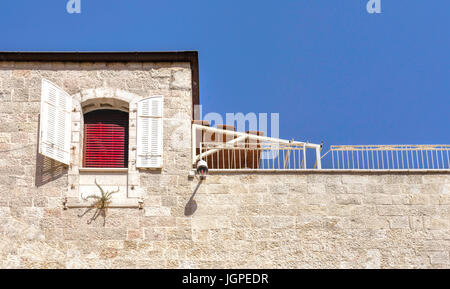 Rote Vorhänge, weißen Fensterläden und blauen Himmel, einen bunten und malerischen Eindruck in das armenische Viertel von Jerusalem, Israel. Stockfoto