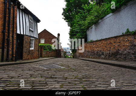 Die steilen Hügel in Lincoln, wieder hinunter in die Stadt hinunter einen alten Ziegel Straße mit alten Gebäuden Stockfoto