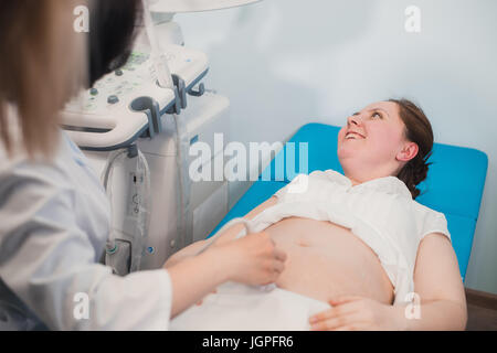 Nahaufnahme von Inkognito Arzt mit Ultraschallgeräte für das screening von schwangeren und drücken Sie auf die Schaltflächen der Spezialcomputer. Frau Diagnose in Klinik Stockfoto