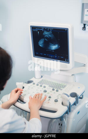 Geschickte Sonographer mit Ultraschall-Maschine bei der Arbeit Stockfoto