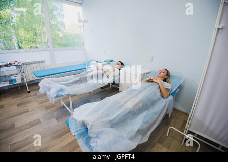 Porträt von Ernst zuversichtlich männlichen Arzt Stand mit verschränkten in Arztpraxis Stockfoto