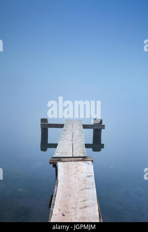 Ein kleiner Steg am Bohinj See in Slowenien an einem nebligen Morgen. Stockfoto