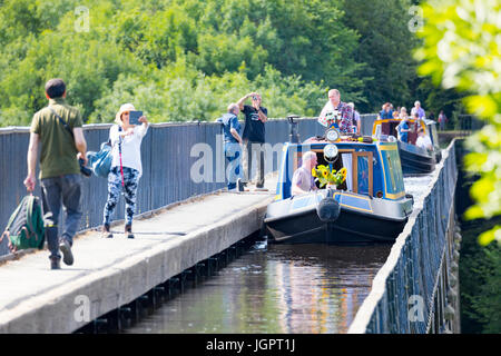 Menschen und schmale Boote überqueren das Pontcysyllte-Aquädukt in den Sommertagen ein UNESCO-Welterbe, Trevor Becken, Wrexham, Wales Stockfoto