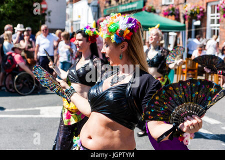 Tribal Banshees Bauchtanz Damen, 30s 40s, Tanzen im Freien im sonnigen Straße. Winkenden Fans und mit Girlande mit Blumen im Haar. Um im Alter von Mitte dreißig bis Anfang der vierziger Jahre. Folk Festival Veranstaltung. Stockfoto