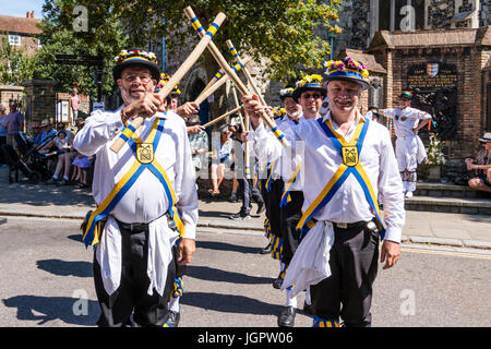 Traditionelle englische Volkstänzer, Yateley Morris Seite tanzen auf der Straße in der mittelalterlichen Stadt, Sandwich während des Folk und Ale-Festival. In zwei Reihen, Kreuzung Holzpfähle. Stockfoto