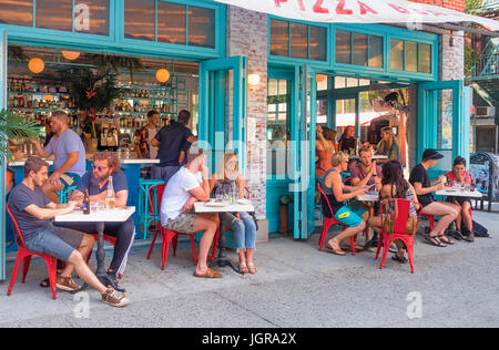 Junge Hipster bei Außengastronomie Pizza Beach in der Orchard Street auf der Lower East Side in New York City Stockfoto