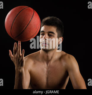Isolierte Bild ein Basketball-Spieler drehen eine Kugel am finger Stockfoto