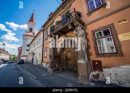 Haus mit Karyatiden (Casa cu Cariatide) in Mitropoliei Straße im historischen Zentrum von Sibiu Stadt, Rumänien. Reformierte Kirche im Hintergrund Stockfoto