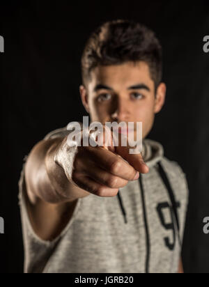 Mann im Hemd auf Kamera zeigen. Schwarzem Hintergrund isoliert Stockfoto