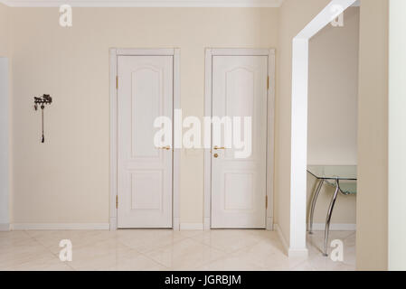Haus innen. Eingangsbereich mit weißen Türen zum begehbaren Kleiderschrank und Toilette. Stockfoto
