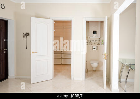 Haus innen. Eingangsbereich mit weißen Türen zum begehbaren Kleiderschrank und Toilette. Stockfoto