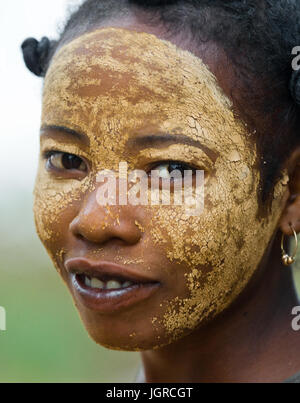 Madagaskar, MORONDAVA - 8. August 2011: Porträt der jungen Frau aus dem Dorf in einer Tonerdemaske auf das Gesicht. Stockfoto