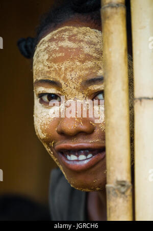 Madagaskar, MORONDAVA - 8. August 2011: Porträt der jungen Frau aus dem Dorf in einer Tonerdemaske auf das Gesicht. Stockfoto