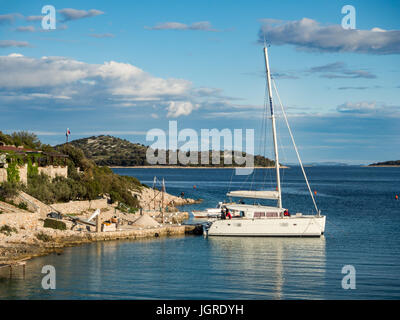 Katamaran angedockt in einer Bucht mit Restaurant in Kroatien bei Sonnenuntergang, Kaprije Insel Zlarin Insel Stockfoto