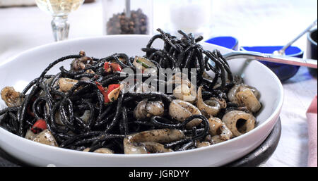 Blick auf leckere schwarze Pasta mit Kalamari (Tintenfisch) und Tinte Stockfoto