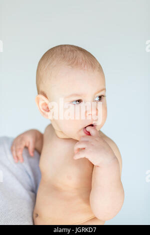 Seitenansicht der Mutter halten entzückenden jungen isoliert auf grau, 1 Jahr alt Baby Konzept Stockfoto