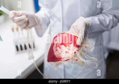 Schuss des Arztes im Laborkittel halten medizinischen Geräte für die Bluttransfusion beschnitten Stockfoto