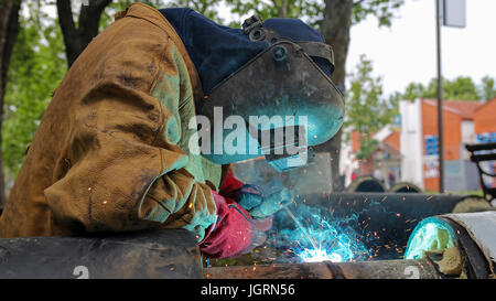 Rohr auf den Rohrleitungsbau Schweißen. Arbeiter mit Schutzmaske Schweißen Metall. Stockfoto