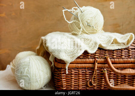 Alte Vintage Wicker-Hobby-Truhe mit weißer Wolle clews, Handarbeiten auf rustikalen Holz Hintergrund, stricken, Basteln-Konzept, Banner, Header-Bild für website Stockfoto