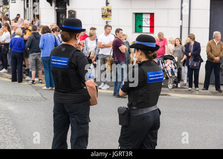 Weibliche Polizei und Community Safety Officers oder PCSO im Dienst Unterstützung der regulären Polizei in der Eisteddfod Straße Parade in Llangollen Stockfoto