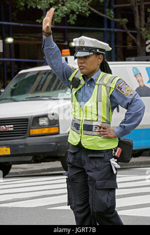 Eine attraktive Polizistin, die Regelung des Verkehrs auf der 34th Street in Manhattan, New York City Stockfoto