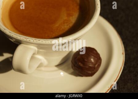 Eine heiße Tasse Kaffee mit Schokolade praline Stockfoto