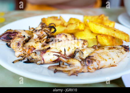 Gegrillter Tintenfisch mit Pommes Frites auf einem Teller. Meeresfrüchte-essen Stockfoto