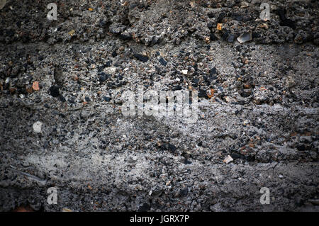 Die dunkle Textur der Betonklotz mit groben Rohsteine. Aggregierte Betontextur Hintergrund ausgesetzt. Betonwand im Grunge-Stil Stockfoto