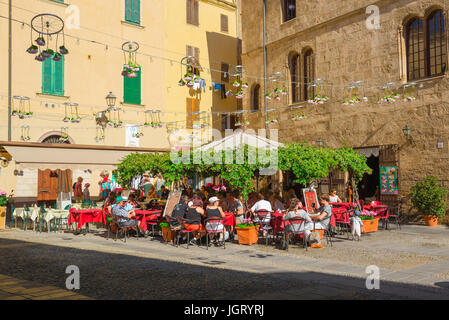 Alghero Sardinien entspannen Personen an Tischen im Freien eine Café-Bar, gelegen in einer sonnigen Ecke der Piazza Civica in Alghero, Sardinien, Italien. Stockfoto