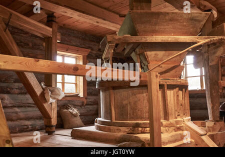 Innerhalb der alten hölzernen Wassermühle festgelegt Fräsmaschine. Sichtbare Zäune aus Holz und die Fenster der Mühle. Mühle aus Baumstämmen hergestellt. Russland, Pskow, Stockfoto