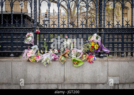 Blumen und florale Hommagen links außen die Beförderung Tor der Houses of Parliament in Erinnerung an die 22 März London Terroranschlag Opfer Stockfoto