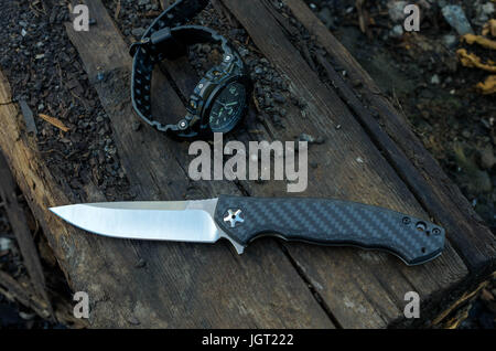 Männliche Set - Messer und Uhren. Schwarze Messer und Uhren. Holz-Hintergrund. Stockfoto