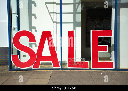 Große rote "For Sale" melden Sie sich an einem Schaufenster -, in großen roten Buchstaben Stockfoto