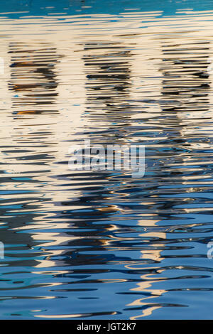 Reflexion von Fenstern in den Wassern des Sees erstellt durch das Licht der untergehenden Sonne bilden unterschiedlicher Größe und Form der Schimmer und Farben Stockfoto