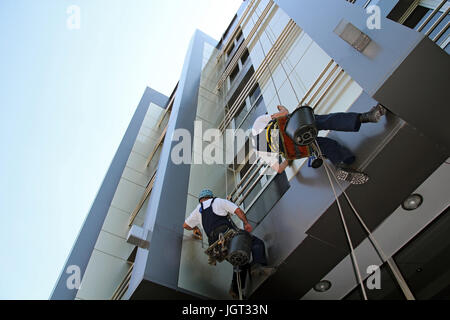 Arbeitnehmer, die Reinigung der Fenster-Fassade eines modernen Bürogebäudes. Stockfoto