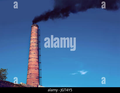 Fabrik Schornstein A Fabrikschlot mit steigenden Rauch unter blauem Himmel. Rohr aus Wärmekraftwerke Stockfoto