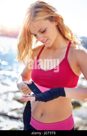 Jungen Boxer Frau einwickeln Hände auf hoher See vor dem Training Stockfoto