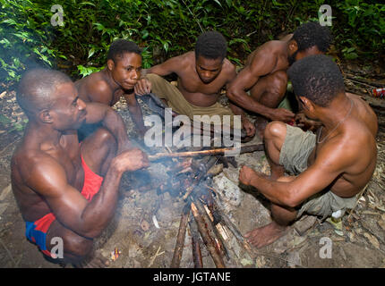 Neuguinea, Indonesien - 13 Januar: Männer Stamm Yaffi sitzen um das Feuer in den Dschungel. Stockfoto