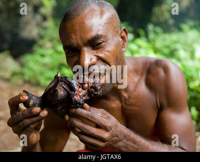 Neuguinea, Indonesien - 13 Januar: Mann Stamm Yaffi eine Stück Fleisch zu essen. Stockfoto