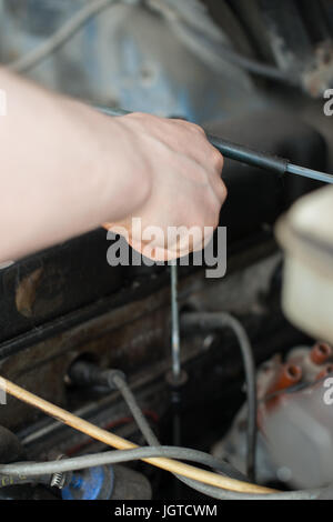 Mechaniker-den Ölstand im Workshop zu messen. Stockfoto